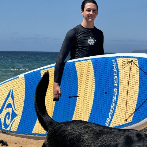 a man standing next to a body of water