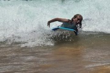a girl riding a wave on a surfboard in the water